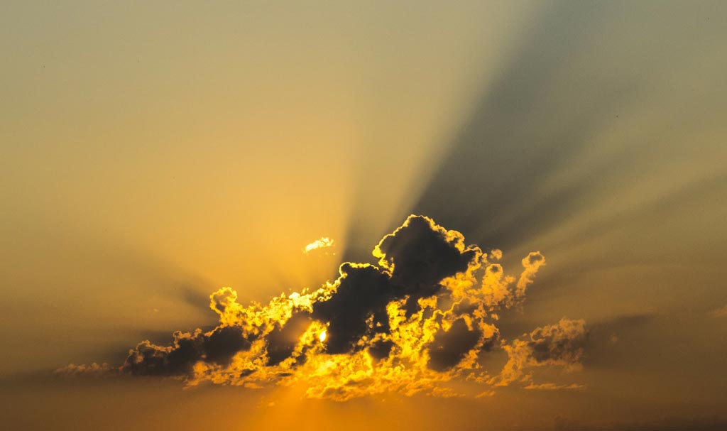 lerver de soleil jaune derrière des nuages bas